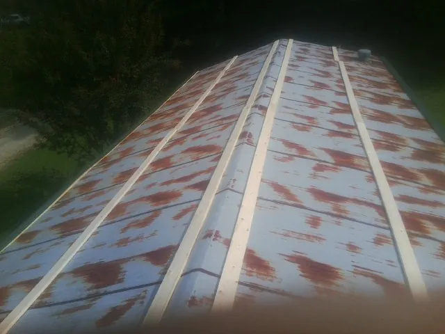 Rusted metal roof panels with new wood purlins before replacement — Storm Damage Roof Repair in Gruetli Laager by Roofing Brothers