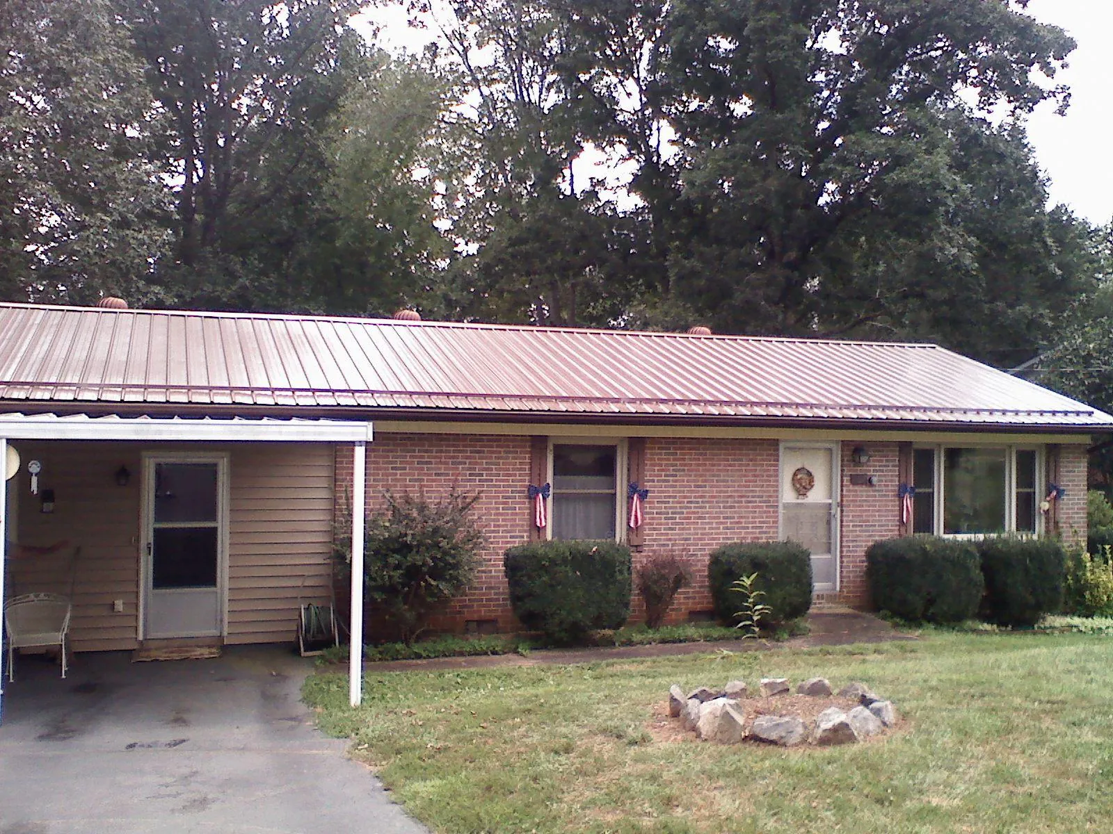 Bronze metal roof and carport on a brick ranch home — Roof Repair work by our crew in Gruetli Laager